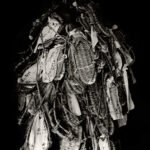 Black and white photograph by Bernard Donjean that shows a mounting of wishful straw sandals donated to the Inariyama Yakurikisha Shrine at Fushimi Inari Taisha Shrine (name of the photograph : Wishful Warajis)