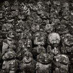 Black and white photograph by Bernard Donjean that shows around forty statues of Rakan in the grounds of the Otagi Nenbutsu-Ji Temple (name of the photograph : Peaceful Rakan Army)