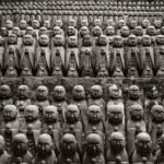 Black and white photograph by Bernard Donjean that shows two hundreds jizo statues exhibited on a wall in Hase-Dera Temple (name of the photograph : Two Hundred Jizo)