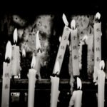 Black and white photograph by Bernard Donjean that shows ten lighting candles (name of the photograph : Candle Offerings)