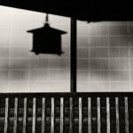 Black and white photograph by Bernard Donjean that shows the shadow of a Japanese hanging lantern thrown on the paper wall of a temple (name of the photograph : The Lantern Shadow)