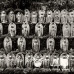 Black and white photograph by Bernard Donjean that shows 31 jizo stones placed on a wall (name of the photograph : Thirty-One Jizo Stones)