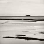 BayBlack and white photograph by Bernard Donjean that shows the Mont Tombelaine far away in the Mont-Saint-Michel Bay (name of the photograph : Mont-Saint-Michel Bay)