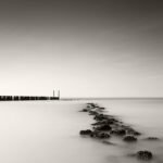 Black and white photograph by Bernard Donjean that shows two breakwaters located in Nieuwesluis (name of the photograph : Breakwater Convergence)