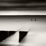 Black and white photograph by Bernard Donjean that shows a brakewater being covered by the rising tide (name of the photograph : Rising Tide)