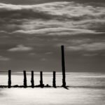 Black and white photograph by Bernard Donjean that shows a single line wood spot breakwater (name of the photograph : Single Line Breakwater)