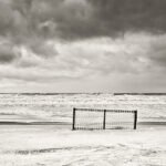 Black and white photograph by Bernard Donjean that shows a fence on the beach of Knokke (name of the photograph : No Place for a Fence)